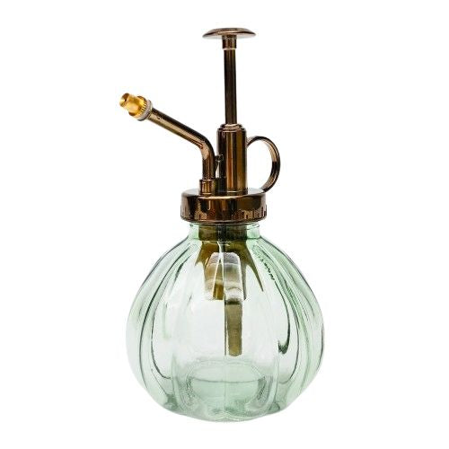 Green glass spray bottle with brass nozzle on a white background