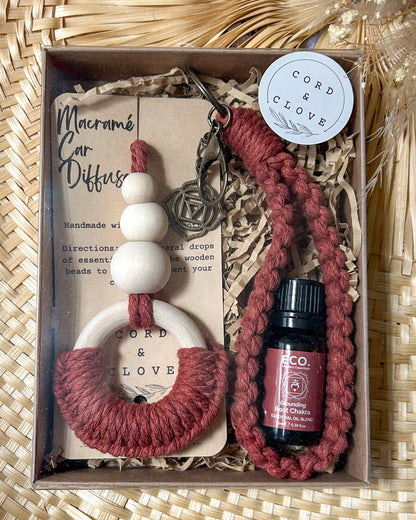 Car diffuser set with bottle and keychain in a box on a woven surface