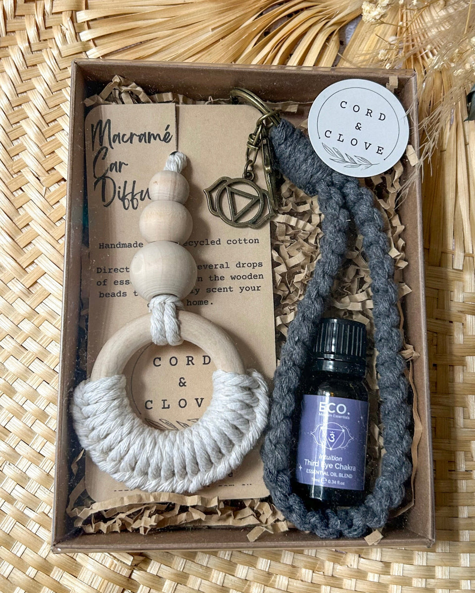 Box containing a Macramé car diffuser, keychain, and bottle of essential oil with 'Cord & Clove' branding.