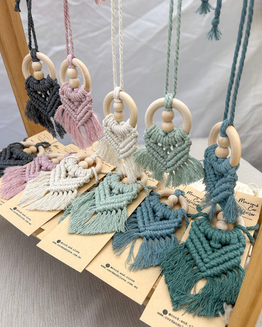 Macrame car charms with wooden beads on a white surface