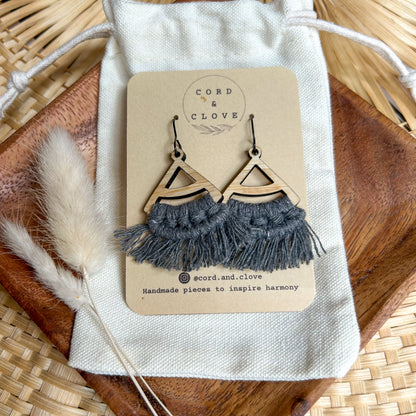 Pair of earrings on a 'Cord & Clove' branded card with dried plants and wood in the background.